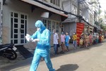 Nhân viên y tế khẩn trương làm thủ tục xét nghiệm cho người dân tại phường 15, quận Bình Thạnh - Ảnh: HCDC