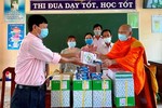Đại diện Trường Tiểu học 2, xã Định Hòa tiếp nhận quà cho học sinh khó khăn của trường - Ảnh: CTV