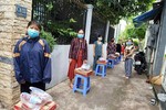 Người dân ở khu vực phong tỏa hẻm C8, đường Phạm Hùng, huyện Bình Chánh nhận quà hỗ trợ
