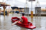 Nhà sư chèo thuyền cạnh một bức tượng Phật bị ngập trong nước lũ tại một ngôi chùa ở Ayutthaya, Thái Lan hôm 6-10