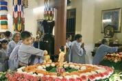 Em thơ được phụ huynh ẳm trên tay để Tắm Phật trong niềm háo hức