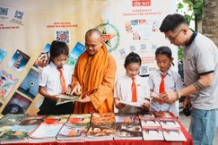 Các em nhỏ tìm hiểu Phật pháp bên những ấn phẩm Báo Giác Ngộ được trưng bày trong khuôn viên tịnh xá Ngọc Thạnh - Ảnh: Đức Huy