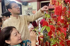 Một du khách nước ngoài trải nghiệm văn hóa đón giao thừa của người Việt Nam nơi cửa thiền - Ảnh: Lyn Trang