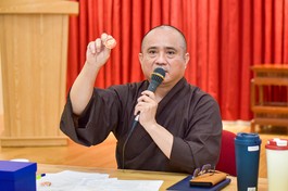 Thượng tọa Thích Tâm Hải giới thiệu biểu trưng (logo) chính thức của sự kiện Kỷ niệm 50 năm Báo Giác Ngộ ra số đầu tiên qua sản phẩm pin - Ảnh: Quảng Đạo/BGN