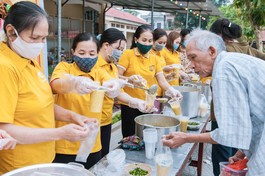 Các tình nguyện viên trao suất cháo đến bệnh nhân nghèo
