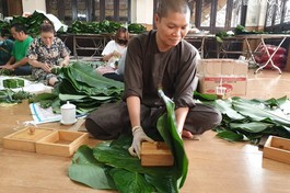 Ni sư Thích nữ Huệ Đức đang gói bánh chưng Tết với lá dong phong vị Bắc
