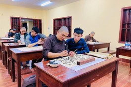 Bạn trẻ đang được thầy hướng dẫn cách viết thư pháp