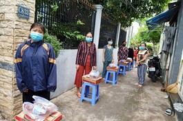Người dân ở khu vực phong tỏa hẻm C8, đường Phạm Hùng, huyện Bình Chánh nhận quà hỗ trợ