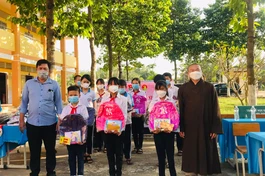 Đại đức Thích Đồng Lợi, trụ trì chùa Khánh An trao quà Tết cho các em học sinh vượt khó học tốt