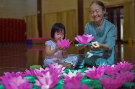 Hai bà cháu tham gia làm hoa đăng tại Việt Nam Quốc Tự - Ảnh: Quảng Đạo/BGN