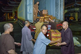 Thượng tọa Thích Thanh Phong cùng chư Tăng chùa Vĩnh Nghiêm (Q.3, TP.HCM) vận chuyển các thùng mì lên xe để chuyển ra các tỉnh phía Bắc vào tối 12-9- Ảnh: Quảng Đạo/BGN
