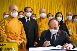 Chủ tịch nước Nguyễn Xuân Phúc ký số tang sau khi dâng hương tưởng niệm Đại lão Hòa thượng Thích Phổ Tuệ - Ảnh: Dân Trí
