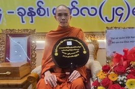 Đại diện Chính phủ Myanmar dâng tặng danh hiệu "Bậc xiển dương chánh pháp - Saddhamma Jotikadhaja" lên Đại đức Thích Thiện Ngọc (Ảnh: TTXVN phát)
