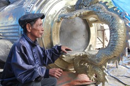 Nghệ nhân Nguyễn Văn Phương bên "Hòa bình phạm chung" do Giáo hội Phật giáo Việt Nam TP.HCM chủ trương tôn tạo, thực hiện tại cơ sở đúc đồng Nguyễn Văn Sở, TP.Huế - Ảnh: Quảng Điền/BGN