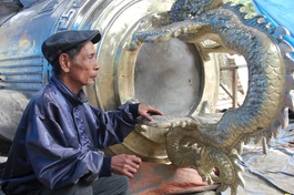 Nghệ nhân Nguyễn Văn Phương bên "Hòa bình phạm chung" do Giáo hội Phật giáo Việt Nam TP.HCM chủ trương tôn tạo, thực hiện tại cơ sở đúc đồng Nguyễn Văn Sở, TP.Huế - Ảnh: Quảng Điền/BGN