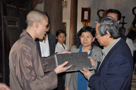 Xem xét mộc bản kinh Phật trong lần đến thăm chùa Vĩnh Nghiêm - Ảnh: VGP/Từ Lương