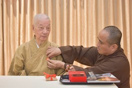 Thượng tọa Thích Tâm Hải, Tổng Biên tập Báo Giác Ngộ đương nhiệm đeo phù hiệu 50 năm Báo Giác Ngộ lên thông y của Đức Pháp chủ GHPGVN tại trụ sở tòa soạn chiều 30-12-2025 - Ảnh: Quảng Đạo