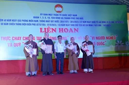 Đại diện Ban Tổ chức liên hoan Ẩm thực chay chung tay vì cộng đồng trao tặng hoa và thư tri ân đến chư tôn đức Ban Trị sự các quận về những đóng góp trong việc chung tay chăm lo cho người nghèo - Ảnh: Bảo Toàn 
