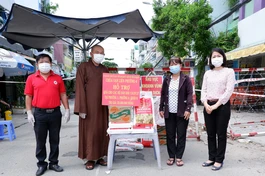 Thượng tọa Thích Lệ Quang cùng chính quyền sở tại trao quà đến các hộ dân bị cách ly