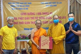 Thượng tọa Thích Minh Quang, đại diện Ban Từ thiện xã hội GHPGVN TP.HCM trao quà đến Hòa thượng Bounma Symaphom - Ảnh: C.Phật Tích