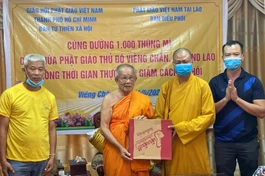 Thượng tọa Thích Minh Quang, đại diện Ban Từ thiện xã hội GHPGVN TP.HCM trao quà đến Hòa thượng Bounma Symaphom - Ảnh: C.Phật Tích