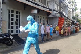 Nhân viên y tế khẩn trương làm thủ tục xét nghiệm cho người dân tại phường 15, quận Bình Thạnh - Ảnh: HCDC