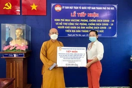 Hòa thượng Thích Minh Truyền trao số tiền ủng hộ đến bà Lê Thị Bấc, Phó Chủ tịch Ủy ban MTTQVN TP.Thủ Đức
