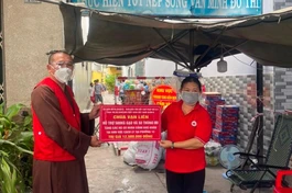 Thượng tọa Thích Lệ Quang trao quà đến đại diện Hội Chữ thập đỏ để tặng những gia đình khó khăn 