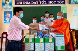 Đại diện Trường Tiểu học 2, xã Định Hòa tiếp nhận quà cho học sinh khó khăn của trường - Ảnh: CTV