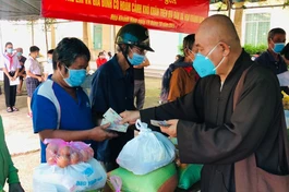 Hòa thượng Thích Chơn Tịnh, đại diện Ban Từ thiện - Xã hội báo Giác Ngộ trao quà đến những gia đình khó khăn - Ảnh: TQ