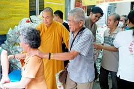 Đại đức Thích Minh Phú hướng dẫn bà con khiếm thị đến nhận quà Tết