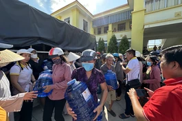 Bà con nhận nước ngọt từ đoàn từ thiện