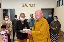 Hòa thượng Thích Duy Trấn trao tiền hỗ trợ của bạn đọc đến bệnh nhân nghèo - Ảnh: BTTXH