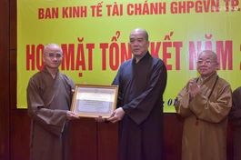 Thượng tọa Thích Thiện Quý thay mặt Ban Trị sự GHPGVN TP.HCM trao Bằng tuyên dương công đức đến tập thể Ban Kinh tế - Tài chính - Ảnh: Quảng Đạo/BGN
