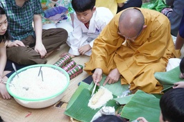 Đại đức Thích Thiện Hưng, trụ trì chùa Tam Bảo hướng dẫn gói bánh tét Tết cho các em thiếu nhi