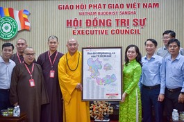 Bà Nguyễn Thanh Xuân tặng bản đồ 168 phường - xã TP.HCM đến Thượng tọa Thích Phước Nguyên - Ảnh: Quảng Đạo/BGN