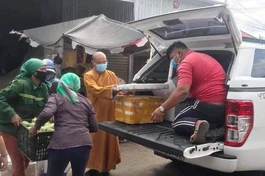 Đại đức Thích Nhuận Độ cùng bà con Phật tử người đồng bào đóng thùng rau củ gửi đến Sài Gòn - Ảnh: NA