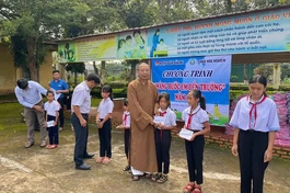 Thượng toạ Thích Quảng Tuấn, trụ trì chùa Hoa Nghiêm, cùng đoàn trao các suất học bổng đến các em học sinh
