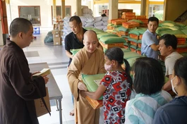 Tặng quà đến người dân khó khăn quận 3 đón Tết tại tổ đình Vĩnh Nghiêm chiều 14-1 - Ảnh: Thanh Tú