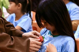 Em xúc động trong khoảnh khắc được cài hoa hồng lên ngực áo - Ảnh: Chùa Thiên Khánh