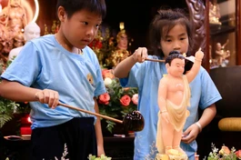 Khoảnh khắc các em thiếu nhi múc nước thơm Tắm Phật đem đến cho các em nhiều hỷ lạc 