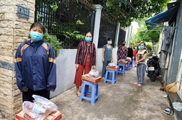 Người dân ở khu vực phong tỏa hẻm C8, đường Phạm Hùng, huyện Bình Chánh nhận quà hỗ trợ