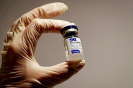 Nhân viên y tế cầm một lọ vắc-xin Sputnik V tại hiệu thuốc ở Moskva - Ảnh: Reuters