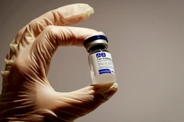 Nhân viên y tế cầm một lọ vắc-xin Sputnik V tại hiệu thuốc ở Moskva - Ảnh: Reuters