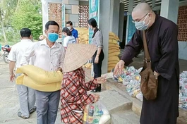 Đại đức Thích Hạnh Huệ tặng quà cho bà con tại UBND xã Huyền Hội