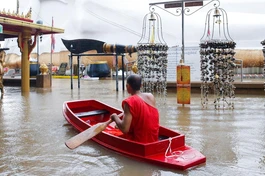 Nhà sư chèo thuyền cạnh một bức tượng Phật bị ngập trong nước lũ tại một ngôi chùa ở Ayutthaya, Thái Lan hôm 6-10