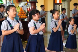 Ý Lạc (thứ hai từ trái qua) cùng các bạn đoàn sinh Gia đình Phật tử tụng kinh tại chùa Xá Lợi - Ảnh: Như Danh/BGN