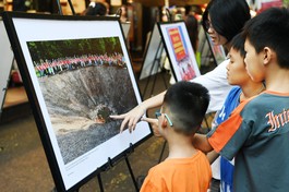 Các em thơ chăm chú xem, tìm hiểu lịch sử tại triển lãm ảnh “Hành trình về nguồn”