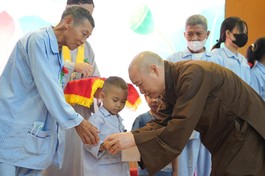 Hòa thượng Thích Bảo Nghiêm đeo chuỗi cho bệnh nhi