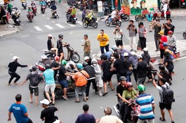 Đám đông xô đẩy, tranh nhau từng tờ tiền rải xuống, tạo cảnh hỗn loạn trên đường phố - Ảnh: Thái Bảo